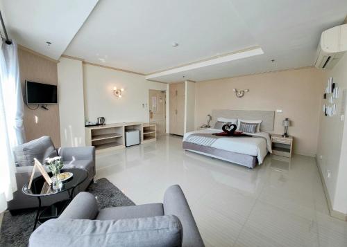 华欣瑟普莱城市酒店的一间卧室设有一张床和一间客厅。