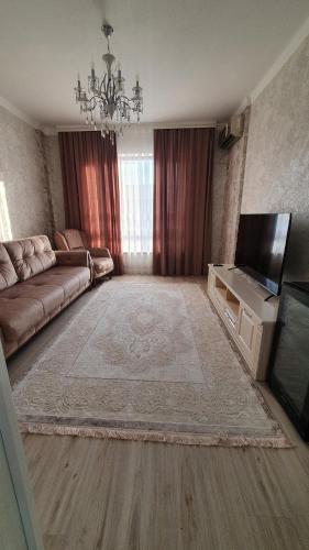 TürkistanKERUEN SARAY APARTMENTS 6/2的带沙发和平面电视的客厅