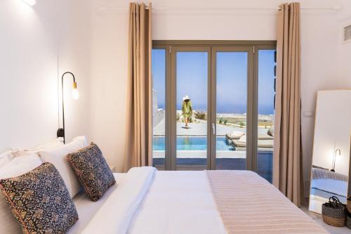 Éxo GoniáLavadoze Luxury Suites的一间卧室设有一张床,享有游泳池的景色