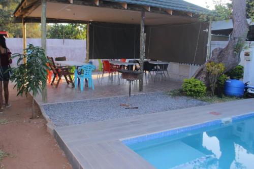 卡萨内Universe GuestHouse的后院设有游泳池、桌子和椅子