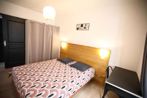 勒唐蓬Villa Pitaya的一间卧室配有一张带木制床头板和一张桌子的床。