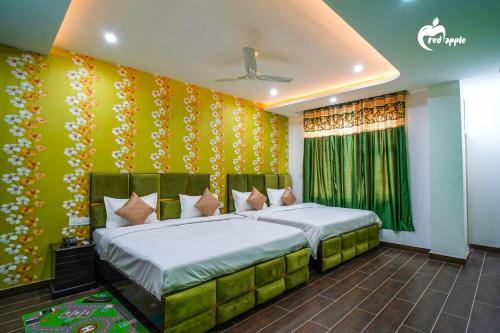 Manī MājraHotel Red Apple Near Railway Station Chandigarh的一间卧室设有两张床和绿色的墙壁