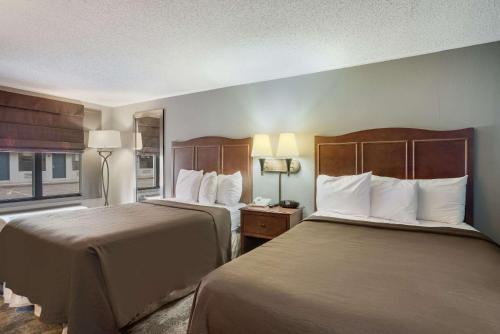 卡莱尔Rodeway Inn的酒店客房设有两张床和窗户。