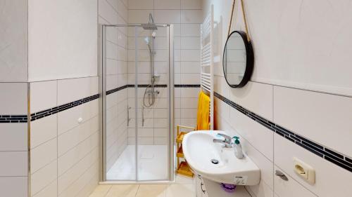 米尔豪森Nina Apartments的白色的浴室设有水槽和淋浴。