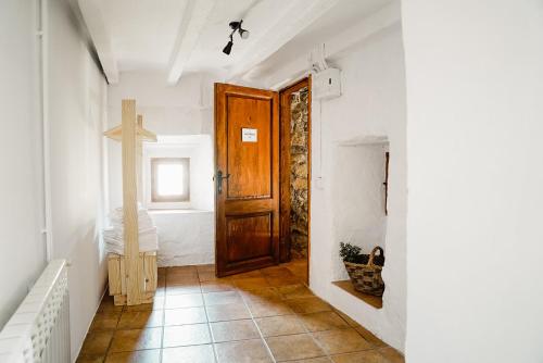 NavésCases Altes de Posada的走廊上设有木门,墙上有十字架