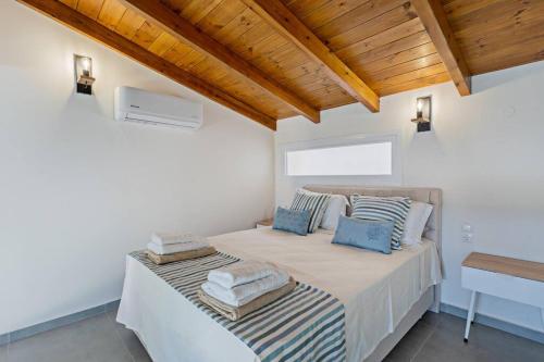 帕诺尔莫斯雷斯蒙Sofia Suite, a seafront hideaway !的白色卧室,配有带毛巾的床