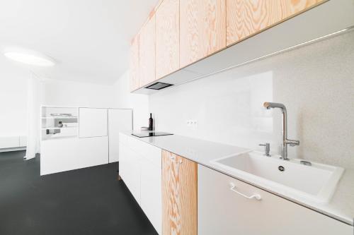 特尔纳瓦White Innk city center apartment的厨房配有白色的柜台和水槽