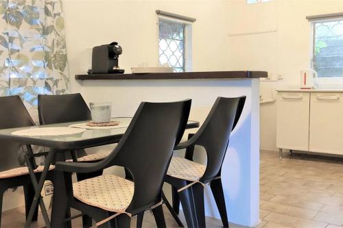 马罗尼河畔圣洛朗Maison dans le quartier historique de St Laurent Résidence Colibri的厨房里设有1间带桌椅的用餐室