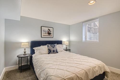 利特尔顿5602 S Spotswood St的一间卧室配有一张床和两张带台灯的桌子。