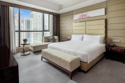 龙岗深圳龙岗珠江皇冠假日酒店的一间卧室设有一张大床和一个大窗户