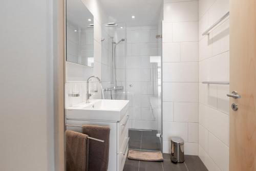 阿罗萨Pranursa的白色的浴室设有水槽和淋浴。