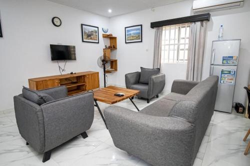 洛美Villa Damas的客厅配有两把椅子、一张桌子和一台电视