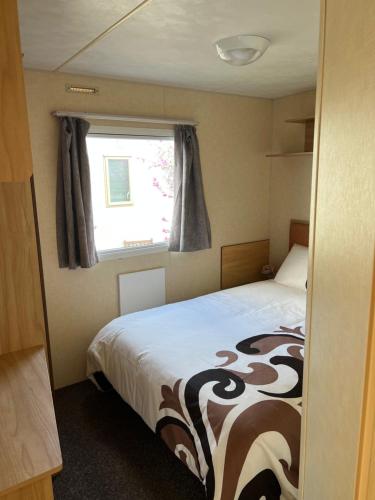阿贝尔格莱Chris’s caravan的一间小卧室,配有床和窗户