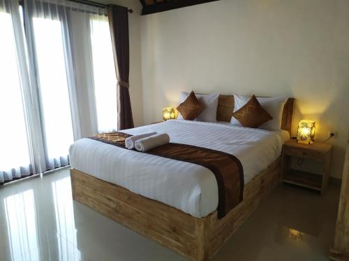 珀尼达岛Bukit keker cottage的一间带一张大床的卧室,位于带窗户的房间内