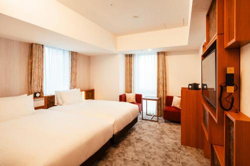东京Keisei Richmond Hotel Tokyo Oshiage的酒店客房设有两张床和电视。