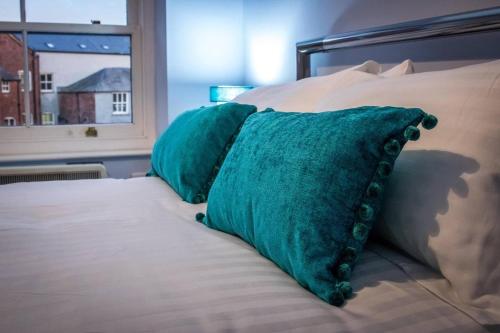 阿尔弗斯顿Beautiful 1-Bed Apartment in central Ulverston的床上的2个绿色枕头,设有窗户
