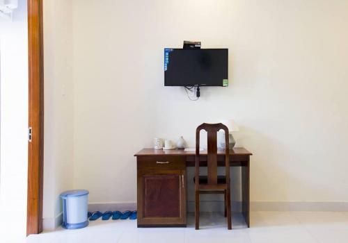 头顿Nhà nghỉ Linh Quân的一张桌子、椅子和墙上的电视