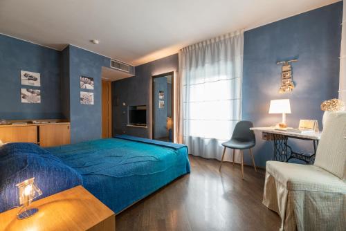 乌迪内套房酒店的蓝色卧室,配有床和椅子