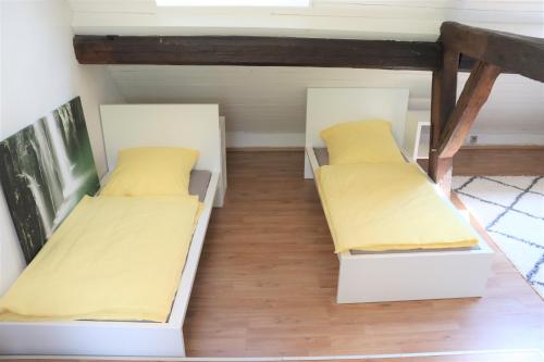 萨尔路易斯Ferienwohnung, Charmantes Bauernhaus, Ferienhaus的小客房内的两张床,配有黄色床单