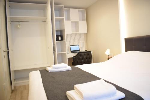 伊斯坦布尔Scope Apartment的一间卧室配有一张床和一张带电脑的书桌