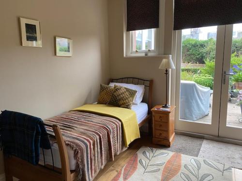 爱丁堡Braid Rd Stunning Villa的一间卧室设有一张床和一个滑动玻璃门