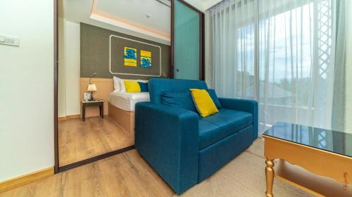 Ban Lum FuangThe Aristo-2-903的客厅配有蓝色的沙发和床。