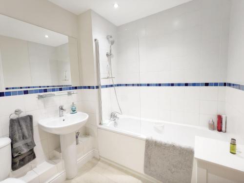埃姆斯沃思Pears Grove - Southbourne的白色的浴室设有水槽、浴缸和卫生间。
