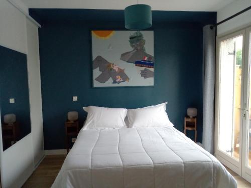 MarckLe gîte de la salicorne的一间卧室设有一张蓝色墙壁的大床