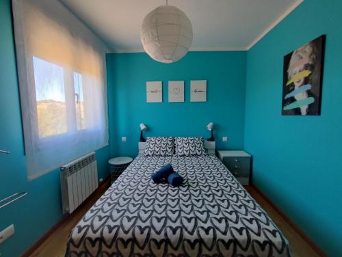 Murillo de Río LezaEl Mirador de Murillo的一间卧室配有一张蓝色墙壁的床