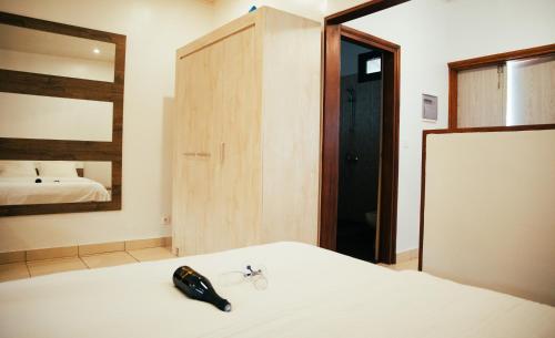 阿比让Résidence Palms Abidjan的一间卧室配有一张带镜子的床和一部电话