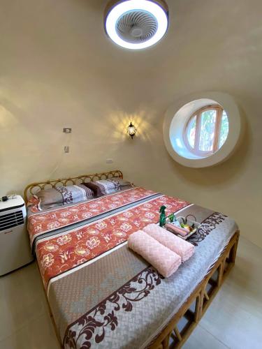 公主港Adorable Dome House的一间卧室设有一张大床和一个圆形窗户。