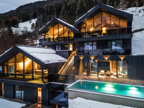 卡普尔Paznauner Villen - Villa II的雪中带游泳池的房子