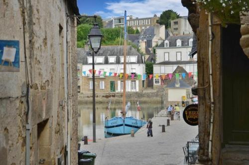 欧赖Très bel Appartement avec superbe vue sur le Port de Saint Goustan的一条狭窄的街道,一条蓝色的船在水中