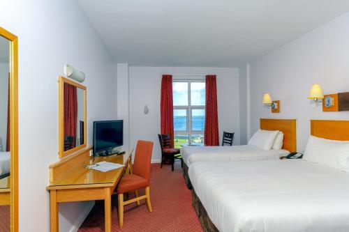 波特拉什波特拉什大西洋酒店的酒店客房设有两张床、一张桌子和一台电视。