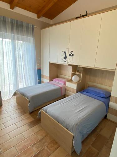 San Demetrio neʼ VestiniCasa Vacanze Boutique House Casa Mimo的一间卧室配有两张床和橱柜。