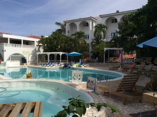 拉纳韦贝Lush Tropical apartment located in a 4-star resort的一座带椅子的度假村游泳池