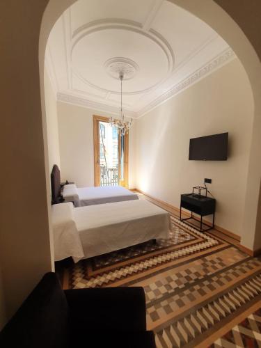 巴塞罗那洛桑酒店的卧室配有一张床,墙上配有电视。