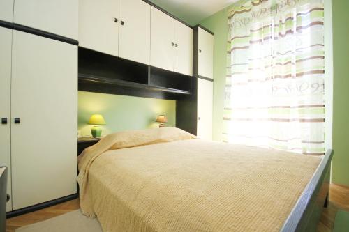 拉茨斯切Apartments by the sea Racisce, Korcula - 9337的一间卧室设有一张大床和一个窗户。
