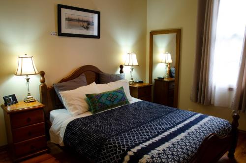Gellibrand盖利布兰德河画廊度假屋的一间卧室配有一张床、两盏灯和一面镜子