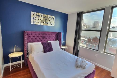 费城The Funky 2bd Apartment next to the convention center and reading terminal的一间卧室配有一张大床和紫色床头板