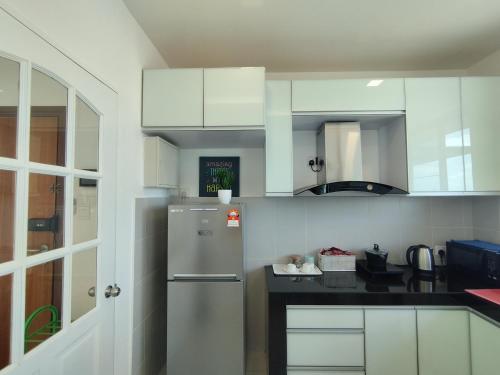 诗巫ONE Homestay A 6Pax 2Rooms的厨房配有白色橱柜和冰箱。