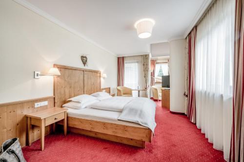 湖城Hotel Weisses Lamm的一间卧室配有一张大床和红地毯