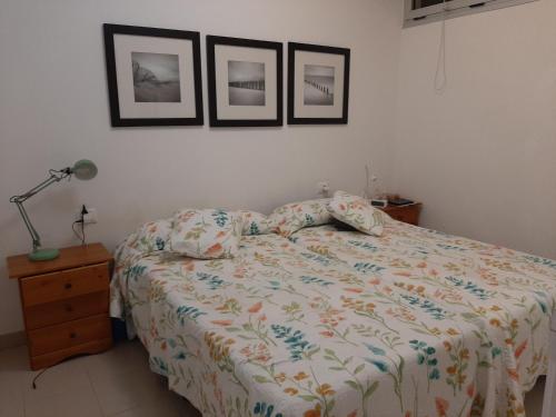 拉拉古纳Laluna的卧室配有一张床,墙上有三幅照片