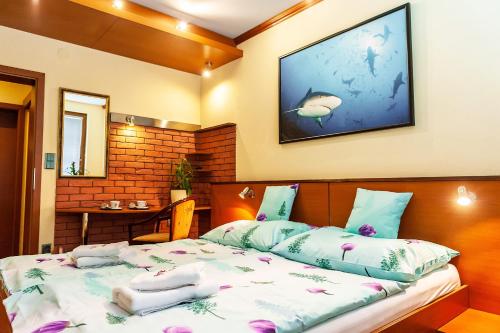 鲁容贝罗克Hotel Áčko的一间卧室配有一张带枕头的床和一台墙上的电视。
