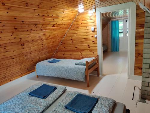 Cosy Holiday Home with sauna for family vacation的一间设有床铺和木墙的房间
