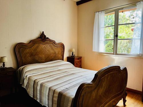 埃斯珀莱特Maison Espelette, 4 pièces, 5 personnes - FR-1-495-2的一间卧室配有一张带木制床头板的床和窗户。