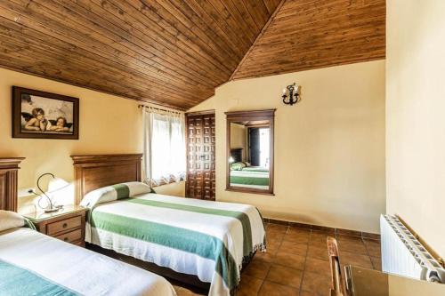 奥尔纳丘埃洛斯Complejo turistico El Álamo的一间卧室设有两张床和木制天花板