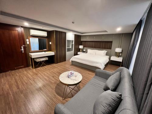 胡志明市Nam Hy 1 Hotel的酒店客房,配有床和沙发