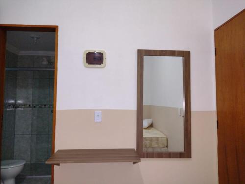 阿帕雷西达Pousada Bela Rainha的浴室设有镜子、盥洗盆和卫生间