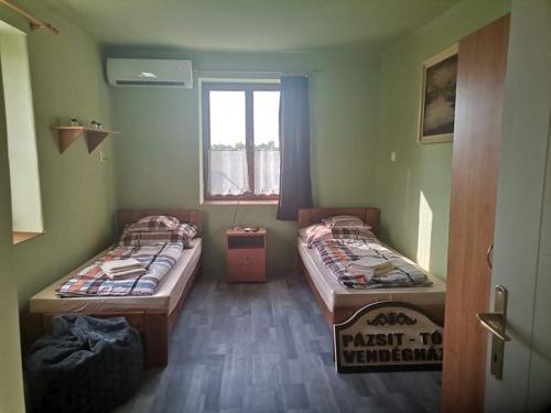 贝凯什圣安德拉什Pázsit-tó Vendégház的客房设有两张床和窗户。